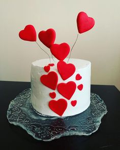 a white cake with red hearts on it