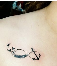 an anchor and birds tattoo on the back of a woman's shoulder, which is drawn in black ink