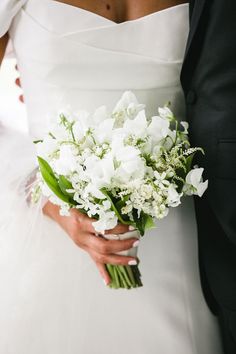 a close up of a bride and groom holding their wedding bouquet in their hands while they both look at each other