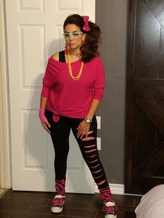 a woman in pink shirt and black leggings standing next to a white door