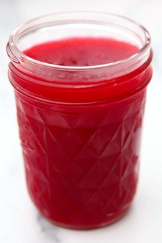 a jar filled with red liquid sitting on top of a table