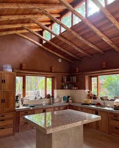 a kitchen with wooden cabinets and an island in the middle, surrounded by wood beams