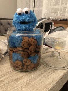 a cookie jar with cookies in it and a cookie monster sitting on the counter top