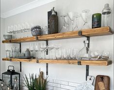 the shelves are filled with wine glasses and other glassware on top of each shelf