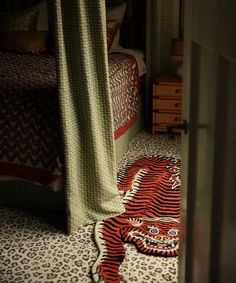 a tiger rug laying on the floor next to a bed