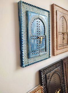 three wooden doors are hanging on the wall next to each other in different colors and designs