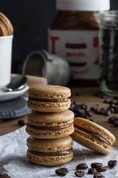 a stack of cookies sitting on top of a piece of wax paper next to coffee beans