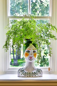 a potted plant sitting on top of a window sill in front of a window