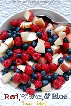 a white bowl filled with fruit on top of a table next to a silver spoon