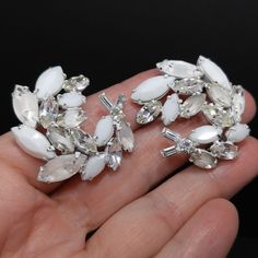 *Description: This is a beautiful Regency Jewels brooch and clip earrings set with white enamel backing, milk glass rhinestones and clear rhinestones in a floral spray brooch and matching earrings. This would be a beautiful set for a wedding or any formal occasion. The brooch and earrings are covered on the back with white enamel and there is a raised cartouche with the REGENCY JEWELS stamp. *Approximate Measurements: Brooch Length - 1 3/4 Inches, Brooch Width - 3 3/4 Inches, Earrings Length &am Glitter Necklace, Formal Earrings, Book Pieces, Enamel Brooch, Floral Spray, 1950s Vintage, White Enamel, Clear Rhinestones, Glass Jewelry