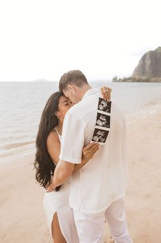 a man and woman kissing on the beach