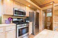 a kitchen with stainless steel appliances and wooden walls