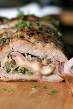 a cut in half sandwich sitting on top of a wooden cutting board with parsley