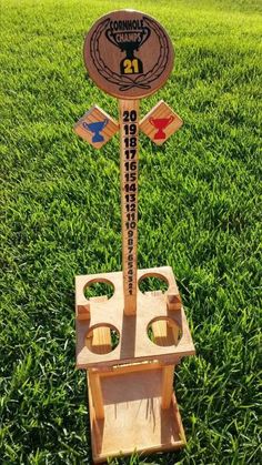 a wooden sign on top of a green field