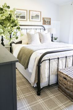 a bedroom with a bed, basket and pictures on the wall