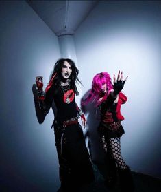 two women dressed in goth clothing posing for a photo