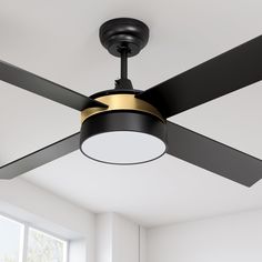 a ceiling fan in a room with white walls and black blades on the blades are gold