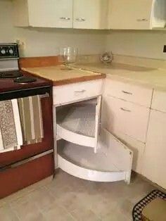 a kitchen with white cabinets and an open dishwasher in the corner next to the stove