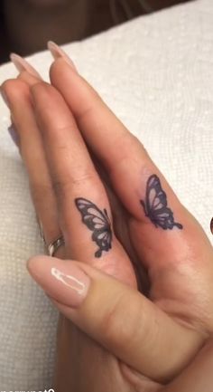 two people with matching tattoos on their fingers