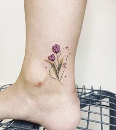 a small flower tattoo on the ankle