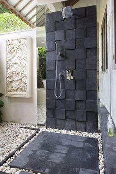 a walk in shower sitting inside of a bathroom next to a stone wall and floor