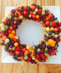 a wreath made out of fruit on top of a white plate