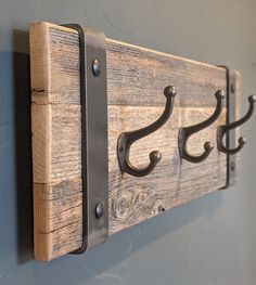 the coat rack is made out of wood and has metal hooks on each hooks