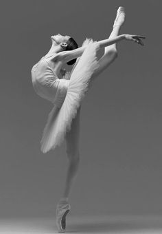 a ballerina in white is posing for the camera