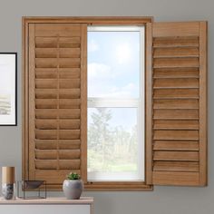 an open window with wooden shutters in a living room next to a white dresser