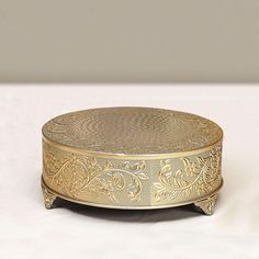 an ornately decorated metal box on a white surface