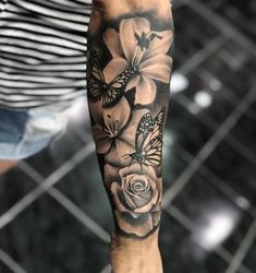 a person with a butterfly and flower tattoo on their arm