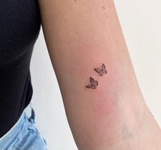 a woman's arm with two small butterflies on the left side of her arm