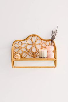 there is a gold metal shelf with candles and toothbrushes in it on the wall