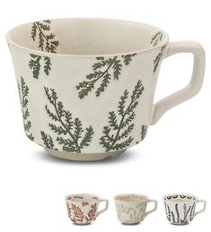 three cups with different designs on them, one is white and the other is green