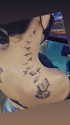 a woman with a book and birds tattoo on her back