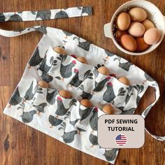 an apron with eggs on it next to a bowl of eggs