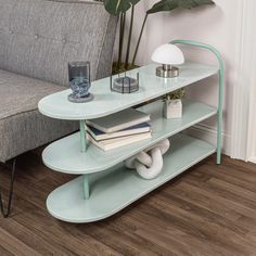 a couch and table with books on it in front of a wall mounted planter