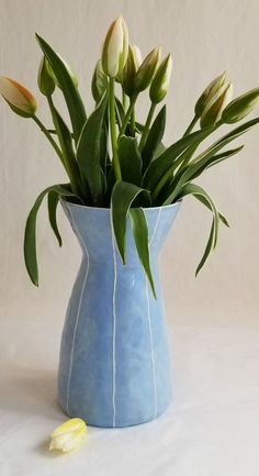 a blue vase filled with flowers on top of a table