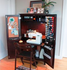 a sewing machine sitting on top of a wooden desk next to a cabinet with pictures