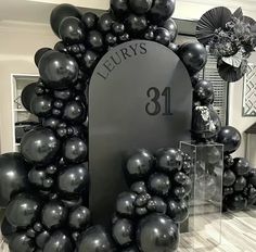 the entrance to leurrys's is decorated with black balloons and an arch