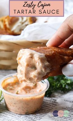 a person dipping some food into a small glass bowl with the words easy cajun tartar sauce on it