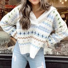 a woman standing in front of a store window wearing ripped jeans and a white sweater