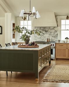 a kitchen with an island and wooden cabinets in the center, surrounded by wood flooring