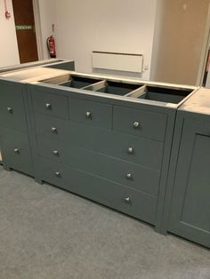 a large gray dresser sitting in a room next to a wall with mirrors on it