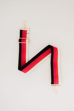 a red, black and white striped lanyard on a white background with gold hardware