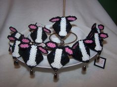 a white plate topped with black and pink knitted sheep