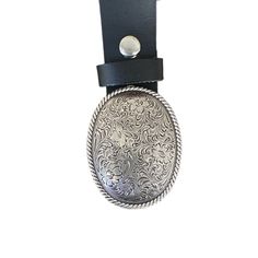 An engraved metal belt buckle with a floral design pulls a great outfit together. A stylish country western buckle really makes a statement and looks great with a pair of jeans and boots. The oval buckle with rope and floral design fits on a belt with a width up to 1 1/2 inches wide.   The buckle dimensions are 3 1/8 x 2 3/8  Fits a belt width up to 1 1/2 inches or 38 mm wide. The belt is not included but may be purchased for an additional cost. All buckles are packaged in organza gift bags for Formal Adjustable Engraved Belt, Formal Adjustable Concho Belt, Engraved Adjustable Western Belt Buckles, Adjustable Engraved Belt Buckles For Western-themed Events, Adjustable Concho Belt Buckles For Western-themed Events, Engraved Adjustable Belt Buckles For Rodeo, Adjustable Engraved Belt Buckles For Rodeo, Adjustable Silver Belt Buckles For Western-themed Events, Silver Belt Buckles For Rodeo