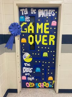 a door decorated with pacman and game over words on the front, as well as a blue ribbon