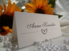 two sunflowers are sitting next to a table with a name card on it