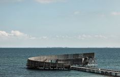 an old wooden structure sitting on top of the ocean